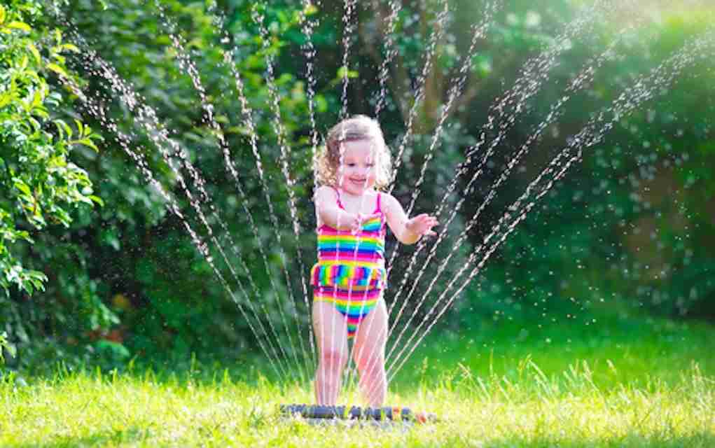 Girl-Playing-in-water-sprinkler-fun outdoor games fun outdoor games
